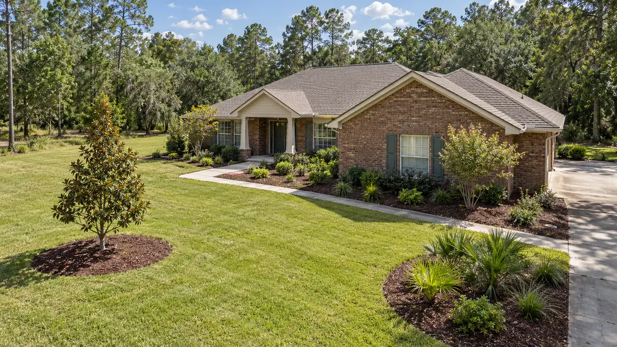 New tree and island beds Concept rendering: young magnolia and island beds planted in the front lawn of a brick home in Nassau County, FL